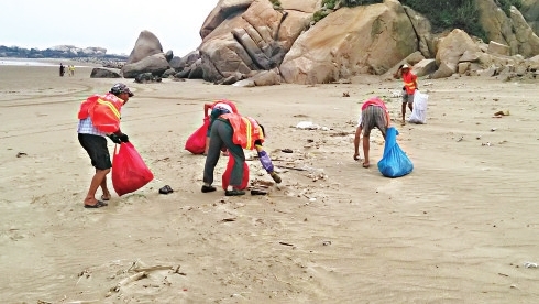 环卫工清理南澳海滩上的垃圾